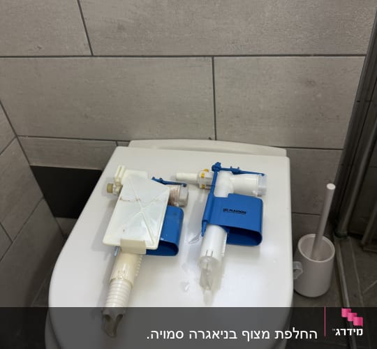 חלקי אינסטלציה על מכסה אסלה בחדר אמבטיה